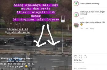 Abang ojol tinggal motor di pinggir jalur busway. (Instagram/@dramaojol.id)